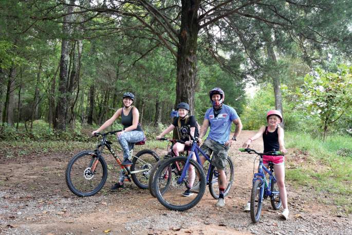 family on bikes in wooded trail
