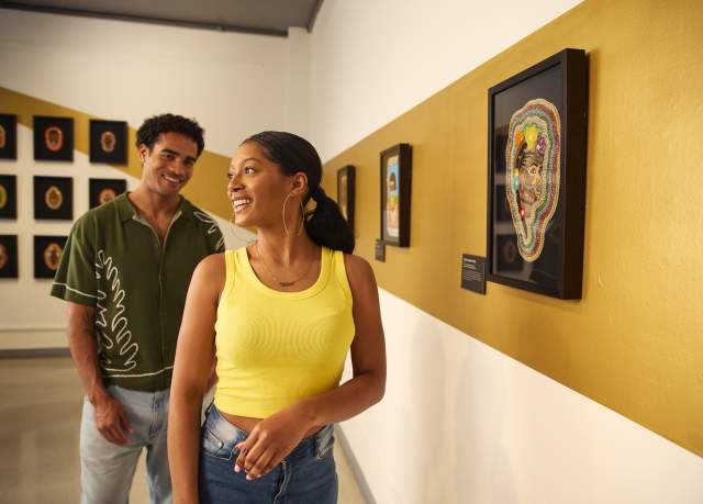 Two African-American adults admire artwork in a museum