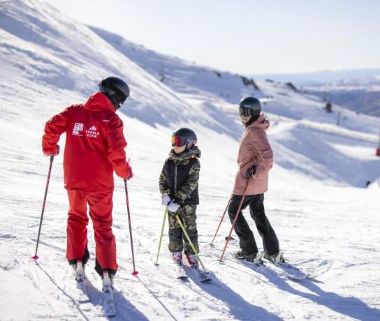 Mother and son having a ski lesson on a snowy mountain