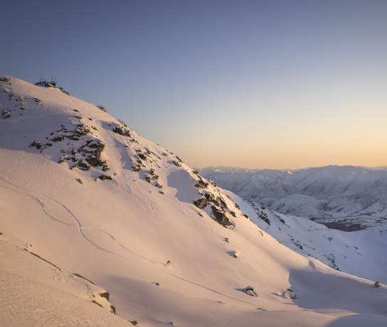 Far shot of person skiing at the Remarkables ski aera at sunrise
