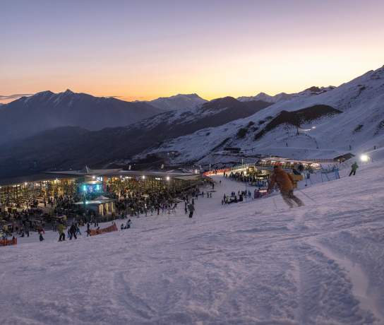 People skiing down mountain during sunset