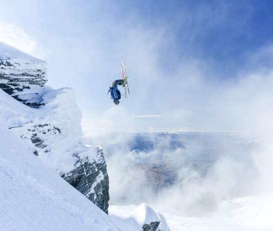 Person doing backflip over rocks at Treble Cone