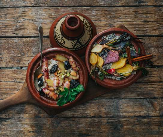 Top down shot of colourful root vegetables in a tagine