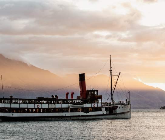 Vintage steamship TSS Earnslaw sailing through Lake Whakatipu at dusk