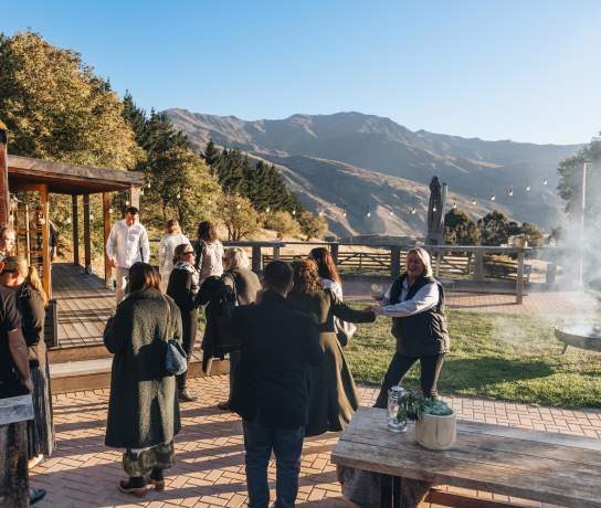 A group of people networking and having fun in an outdoor venue with mountains in the background