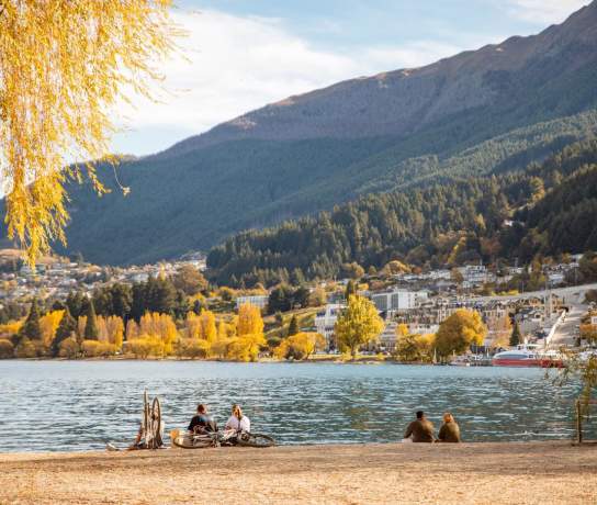A group of friends enjoying the calm autumn day at the Queenstown lakefront