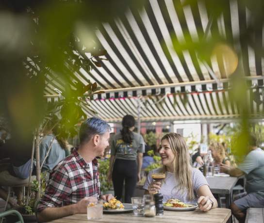 A couple sat at a table enjoying cocktails and brunch at Yonder cafe in Queenstown