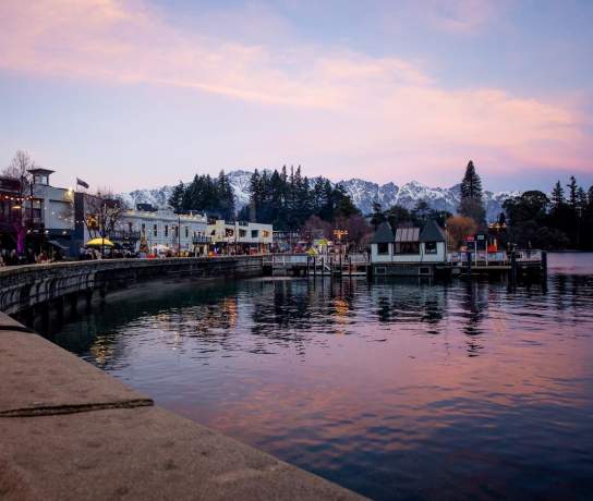Queenstown waterfront in winter at sunset with the Remarkables mountain range covered in snow