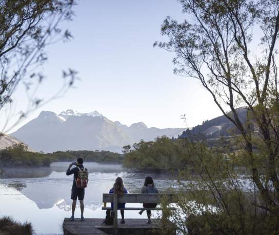 People at the Glenorchy Lagoon Walkway lookout, overlooking lake and mountains