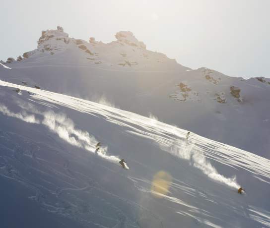 Two skiers shredding the slopes at sunrise