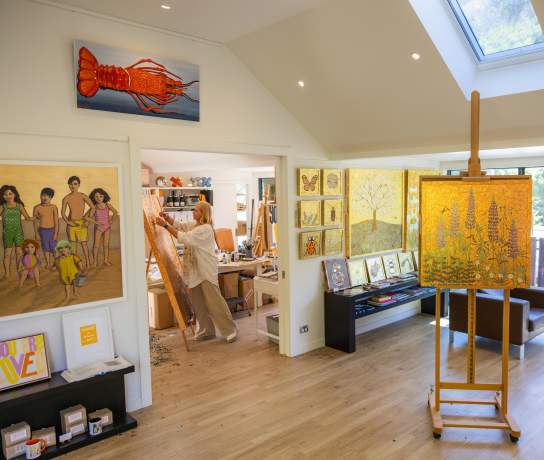 Artist studio with artist painting in the background