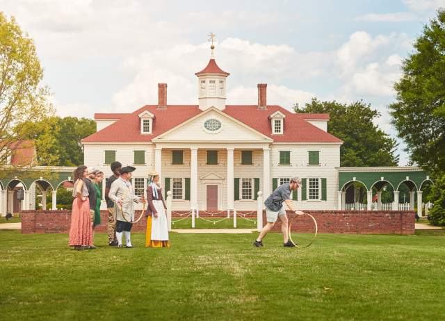 A family plays colonial games with interpreters at The American Village in Montevallo.