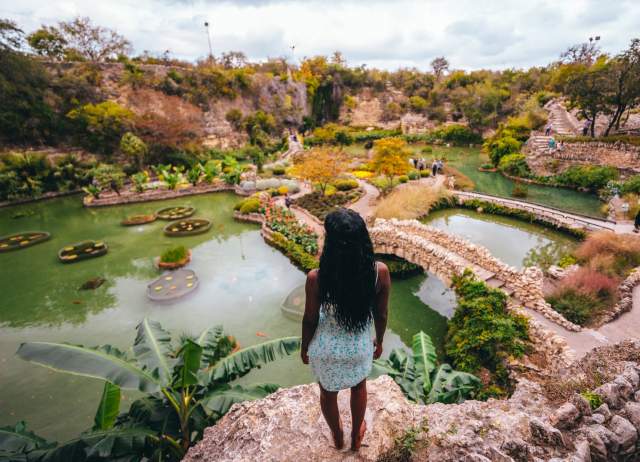 Woman overlooking lush garden and standing water