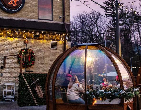 friends eating in a winter dome outside Cafe Hollander in wauwatosa