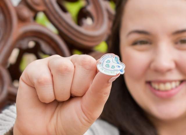 lady holding an art palette lapel pin