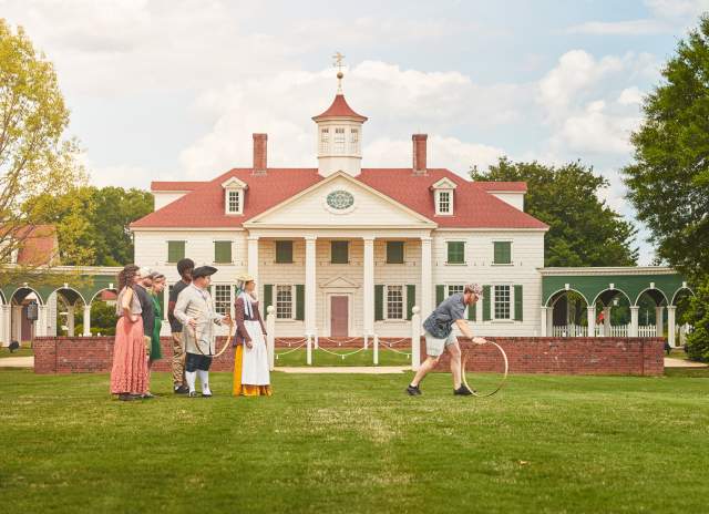 A family plays colonial games with interpreters at The American Village in Montevallo.