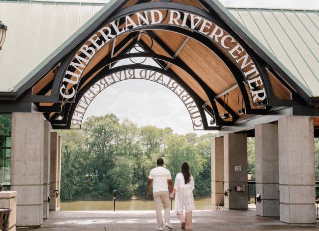couple walking to a river under a large pavilion