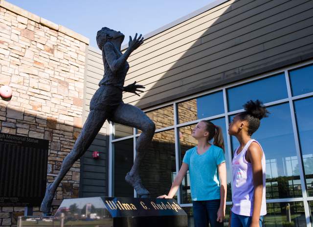 two girls admire the Wilma Rudolph statue
