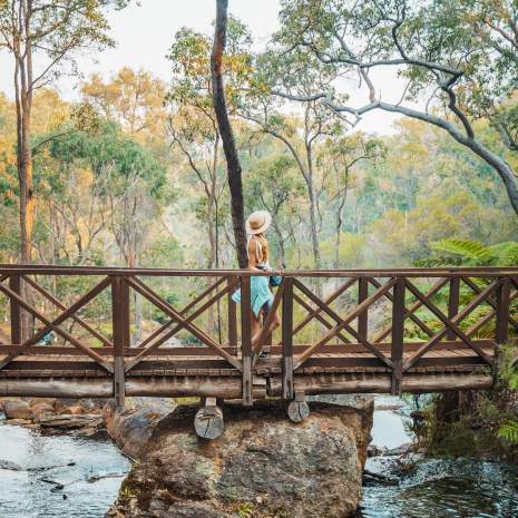 Girls walks across a bridge at Araluen Botanic Park in Armadale