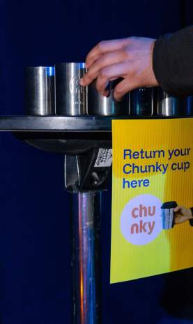 A table at an event filled with reusable chunky coffee cups