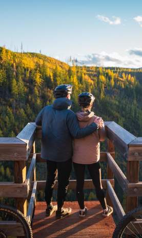Couple taking in the view at Myra Canyon Trestles during Golden Larch Season 1