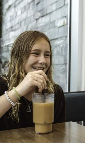 Two kids drinking from a cafe.