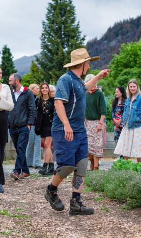 A group of people on a tour through a big vegetable garden