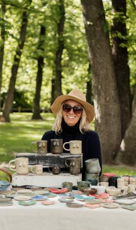 Smiling stallholder with clay crafts at Arrowtown Market