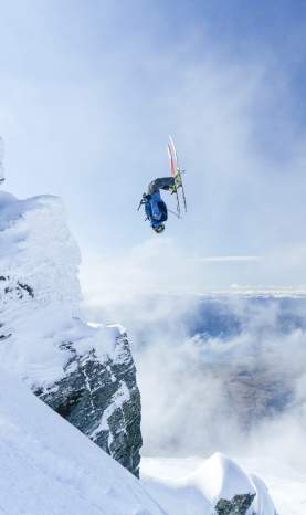 Person doing backflip over rocks at Treble Cone