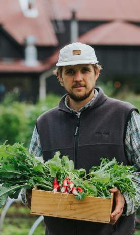 Man holding a box of radishes in the Sherwood Garden