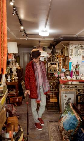 A well dressed individual show casing their store of vintage finds.