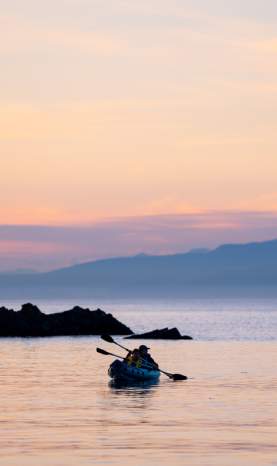 Two people kayaking as the sun sets