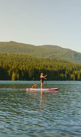 A person stand-up paddle boarding on a lake