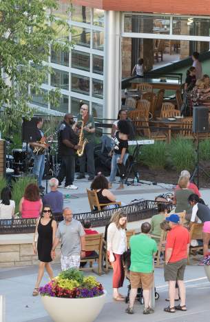 A brass band plays while people walk by and enjoy the music.