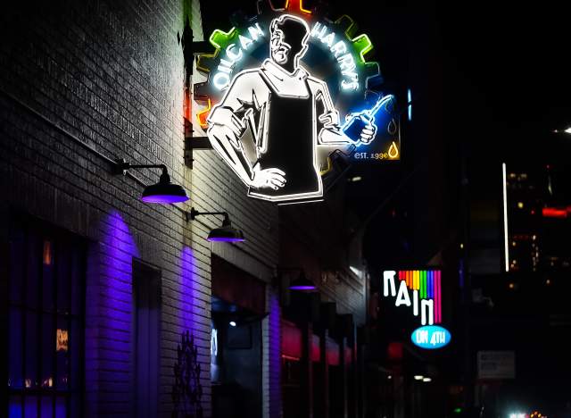 Neon signs in night for Oilcan Harry's and Rain on 4th.