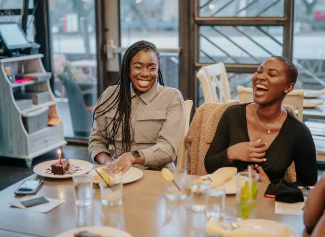 Two female friends laugh together while dingin at Mandala Kitchen and Bar in Austin