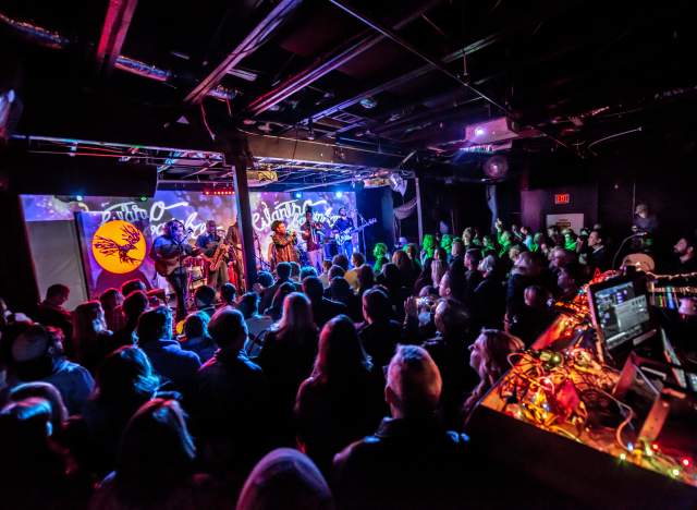 Crowd in front of technicolor lit stage at Empire Control Room.