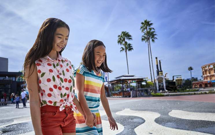 Two girls walking across a splash pad at Universal Citywalk Orlando