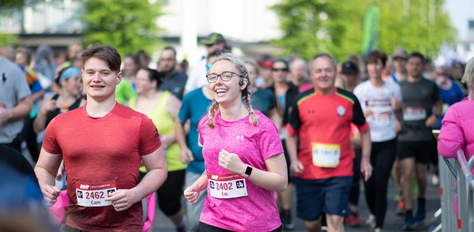 ABP Marathon runners smiling as they run past camera