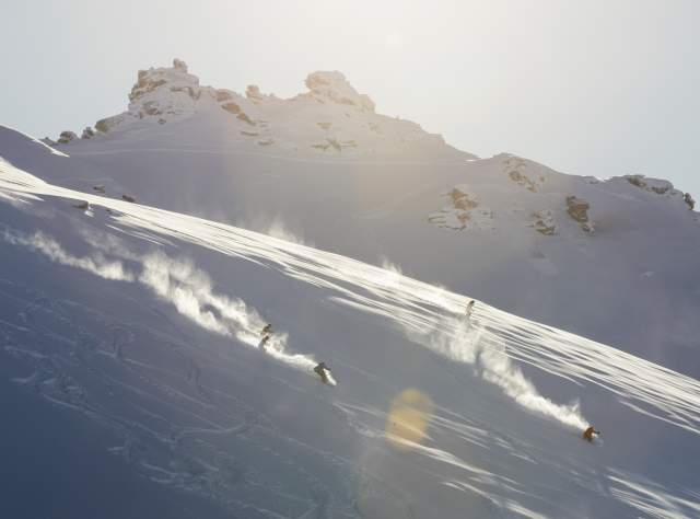 Two skiers shredding the slopes at sunrise