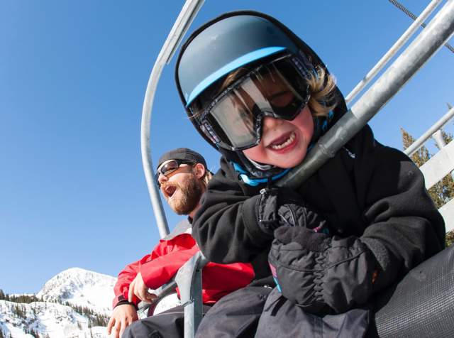 Dad and son on ski chairlift at Brighton