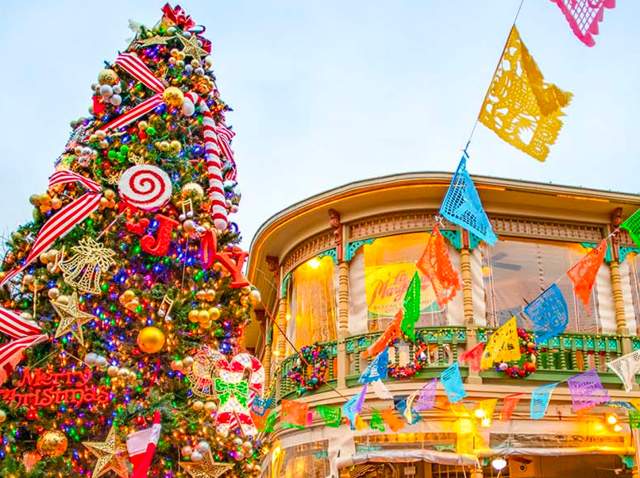 Festive Christmas tree next to papel picado