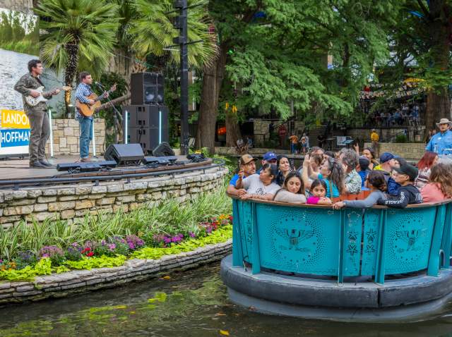 River barge floating by with people and man singing at Arneson River Theatre