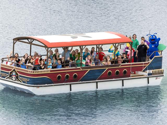 Group of people on covered boat waving