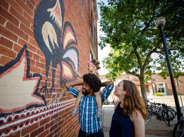 Family exploring downtown mural of Polish Chickens