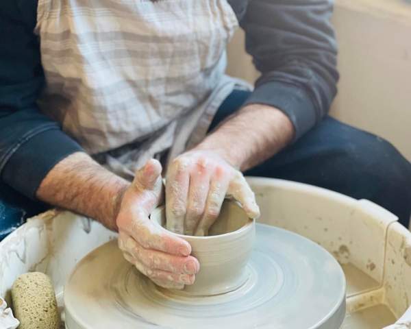 people working on a pottery wheel