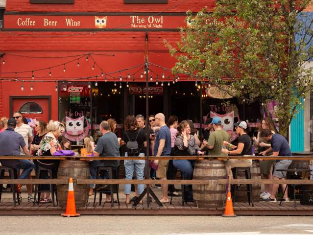 People dining outdoors at The Owl in Milan, MI