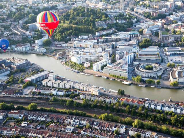 An aerial view of hot air balloons flying over Bristol Harbourside