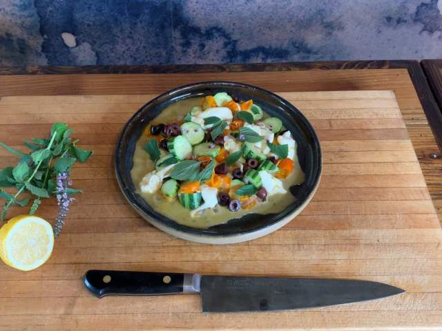 Mozzarella Salad with chefs knife and sliced lemon and herbs from Intero in Austin Texas