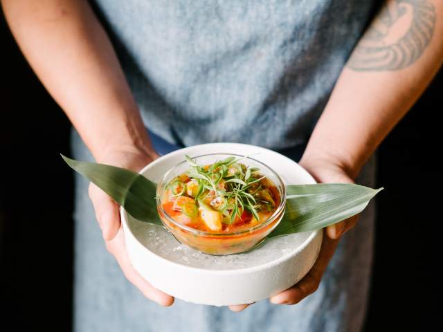 Person holds bowl of ceviche from La Condesa in Austin Texas